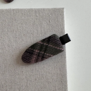 Close-up of a vintage British style plaid hair clip with green and purple wool texture