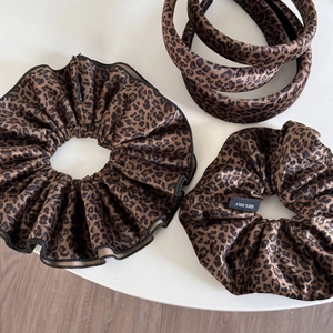 Flat lay detail of leopard print velvet scrunchies and thick sponge headbands set