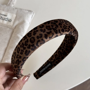 Detail showing the thick leopard print velvet headband with handmade inner label