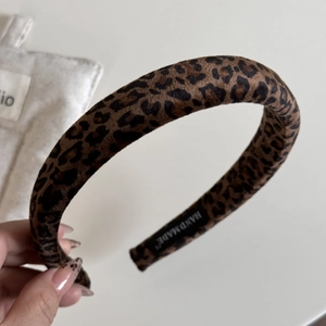 Detail showing the inner black handmade label on a velvet leopard print oversized scrunchie