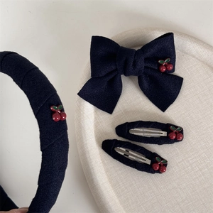 Lot de barrettes en tissu bleu marine avec cerises sur un plateau décoratif