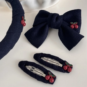 Détail de l'ensemble d'accessoires cheveux en tissu bleu marine avec cerises brodées