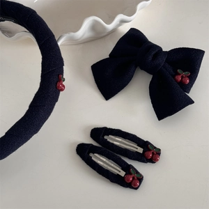 Détail de l'ensemble d'accessoires à cheveux en velours marine avec broderie cerise