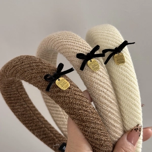 Three knitted winter headbands in brown and beige with velvet bows and gold metal charms
