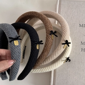 Detailed close-up of knitted velvet bow headbands in various colors with gold charms