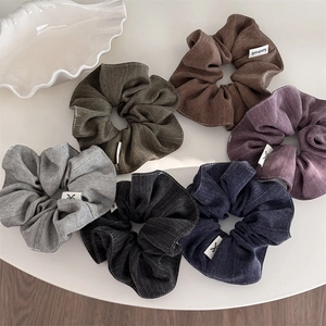 Close-up of 6 herringbone fabric scrunchies with handmade labels in vintage colors