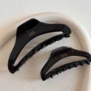 Glossy black acetate hair claw set with gold logo for elegant French style updos