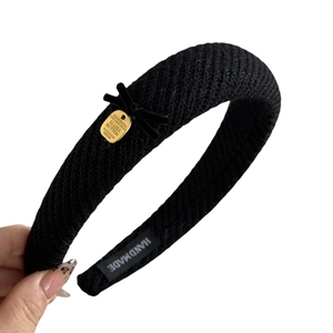 Elegant black velvet bow headband with gold metal plate and thick knit texture design