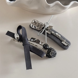 Detail shot of grey fabric bow hair clips with silver chains and crystal charms