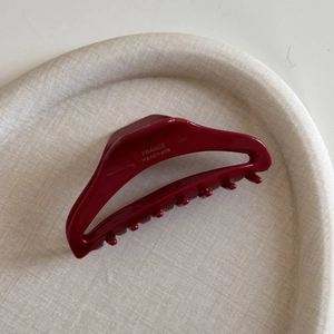 Detail of dark red acetate hair claw clip showing the gold France Handmade engraving