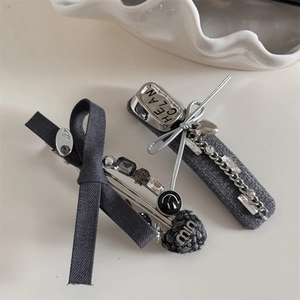 Close-up of grey fabric hair clips with a metallic chain and knitted heart detail