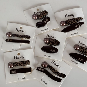 Detail of leopard print hair clips with champagne pearls and dark brown acetate finish