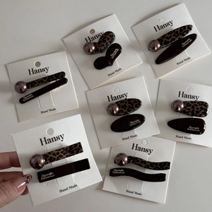 Detailed macro view of leopard print hair clips and resin barrettes on a display card