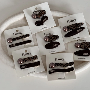 7-piece leopard print and coffee brown hair clip set with gold lettering on cards