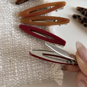 Détail de barrettes en acétate ambré et motif léopard avec clips métalliques robustes