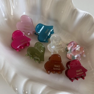 Set of 8 colorful acetate heart-shaped hair claws in a seashell ceramic display