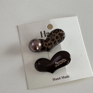 Detail of leopard print and heart-shaped hair clips with Barrette La France gold lettering