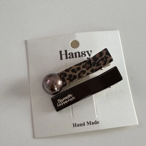Leopard print and black hair clip set with gold lettering on white card packaging