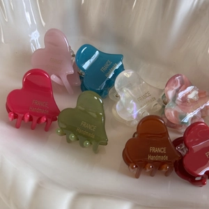 Mini heart-shaped acetate hair claw clips set in various colors with handmade gold lettering