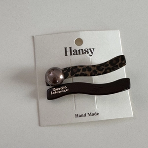 Detail of leopard print and brown wave hair clips on display card with gold lettering