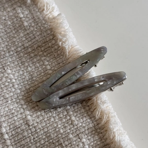 Détail de barrettes à cheveux en acétate marbré avec base métallique argentée robuste