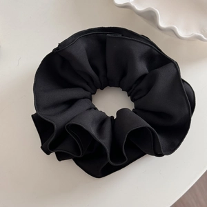 Detailed macro view of black oversized ruffled scrunchie with twill fabric texture