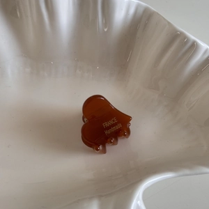 Detailed close-up of small amber acetate heart hair claw with gold France Handmade logo