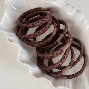 Brown leopard print high-elastic hair ties set neatly arranged in a white shell dish