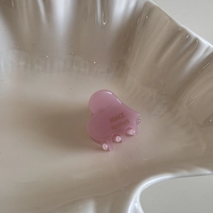 Detail of pink acetate heart hair claw with France Handmade text on shell tray