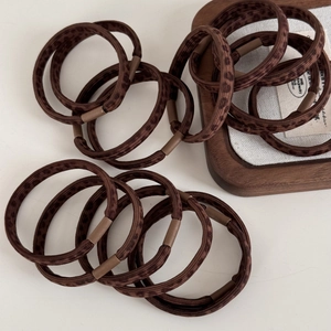 Detail of coffee leopard print high-elasticity hair scrunchies on wooden tray
