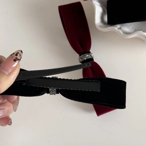 Detail of velvet bow hair clips with rhinestones showing the metal duckbill clip back