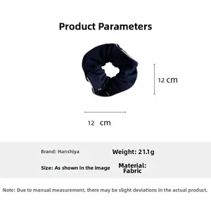 Détail macro du chouchou en tissu bleu marine montrant la taille 12cm et le poids