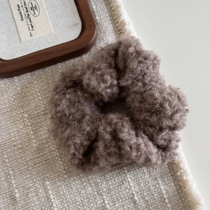 Gros plan sur un chouchou en peluche marron café avec texture laine d'agneau pour l'hiver