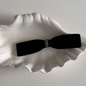 Detail view of a vintage black velvet bow hair clip with sparkling silver rhinestones