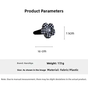 Detail view of checkerboard pattern fabric flower hair clip with pearl center and 10cm size