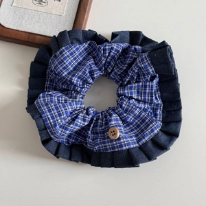 Detail of blue plaid scrunchie with denim trim and a vintage wooden button decoration