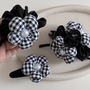Detail of vintage black and white checkered flower hair clips and scrunchie with white pearls