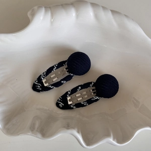 Détail de barrettes en tissu bleu marine avec lettrage life blanc sur plateau
