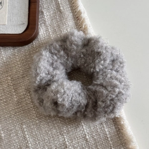 Vue macro détaillée de la texture du tissu peluche gris sur le chouchou élastique épais