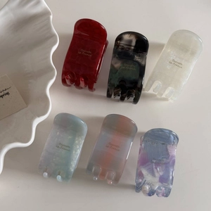 Close-up of six assorted acetate hair claws in various elegant patterns and colors