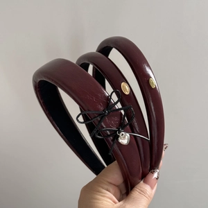 Three-piece set of burgundy faux leather headbands with bow and gold-tone metal charms