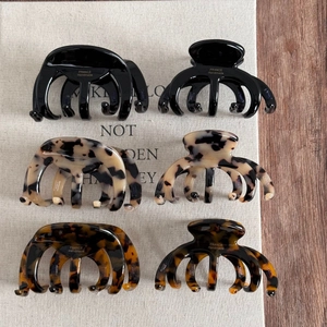 Flat lay of six large acetate octopus hair claws in black and tortoiseshell finishes