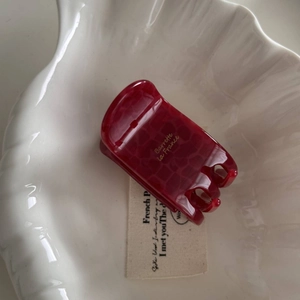 Macro detail of wine red marble acetate hair claw clip with golden French lettering