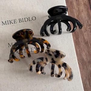 Classic French tortoiseshell acetate hair claws in black, brown, and beige leopard print