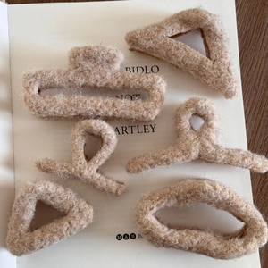 Lot de 6 pinces à cheveux en peluche abricot aux tons chauds d'automne sur un livre