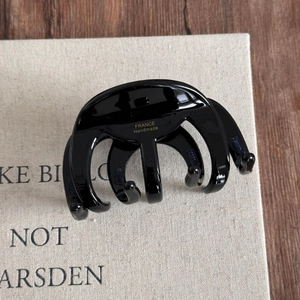 Detailed view of large black hair claw with France Handmade inscription on glossy finish