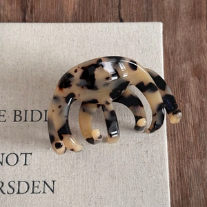 Close-up of crescent-shaped tortoiseshell acetate hair claw with France Handmade gold text