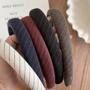 Détail de la texture des serre-têtes en tissu rayé épais en beige marine bordeaux et noir