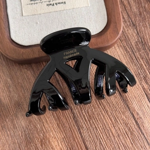 Gros plan du lettrage doré FRANCE Handmade sur une pince à cheveux noire polie