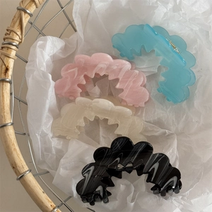 Detailed set of four resin hair claws in blue and marble patterns on white paper